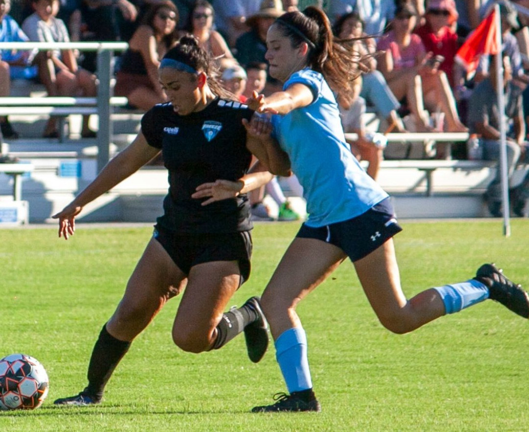 Fresno Freeze women's soccer player battles over the soccer ball in a match at Keith Tice Park