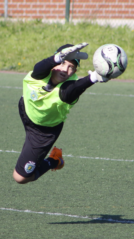 A young soccer goalkeeper dives for a ball during his private soccer goalkeeper lessons in Fresno