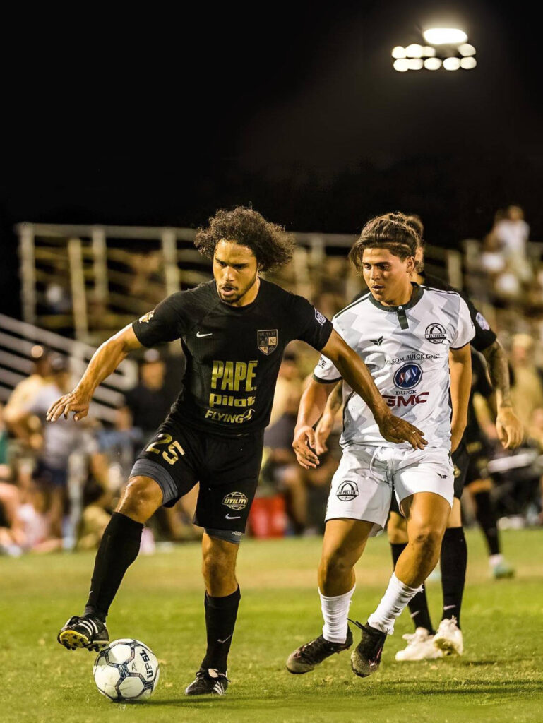 Valley 559 FC players battle for the soccer ball in front of fans at a local Fresno semi-pro soccer game